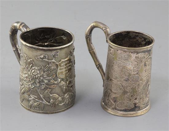 A late 19th/early 20th century Chinese repousse silver christening mug by Wang Hing, Hong Kong, and 1 other.